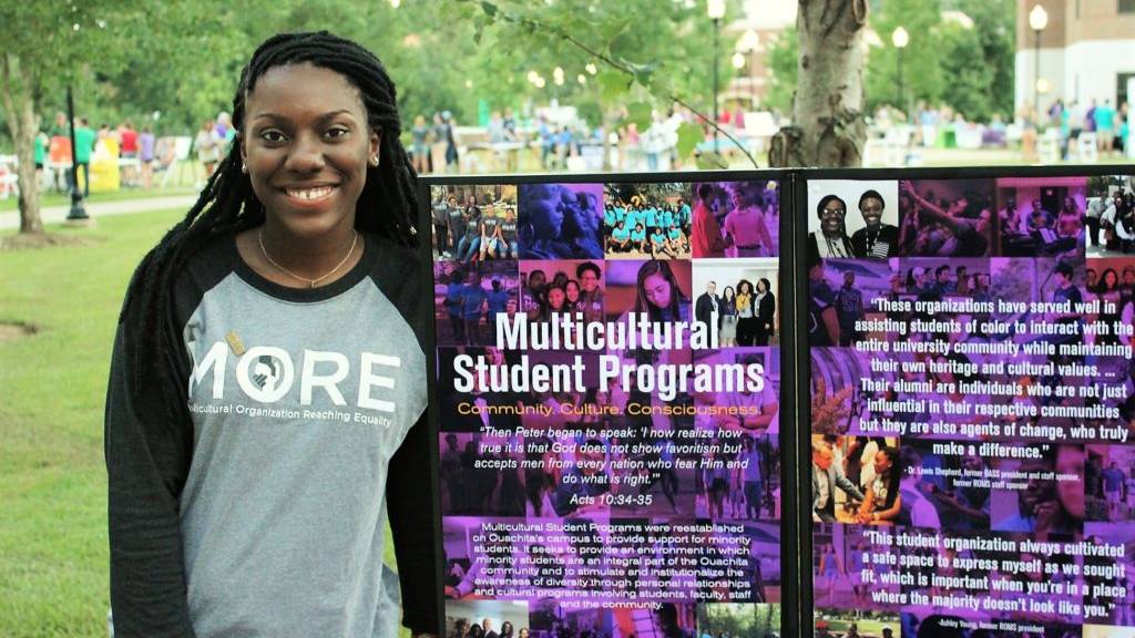 De'Ja poses with MORE poster